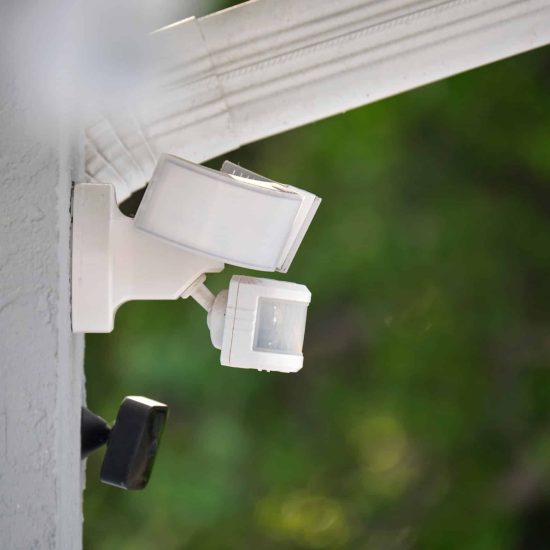 Motion sensor with light detector mounted on exterior wall of private house as part of security system Motion sensor with light detector mounted on exterior wall of private house as part of security system.